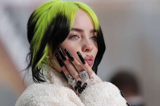 FILE - In this Feb. 9, 2020 file photo, singer Billie Eilish arrives at the Oscars in Los Angeles. The Elton John-led starry benefit concert that featured Eilish, Mariah Carey and Alicia Keys on Sunday has raised nearly $8 million to battle the coronavirus. The musicians performed from their homes for the hour-long event that aired on Fox and iHeartMedia radio stations. Fox will re-broadcast the concert on Monday, April 6.