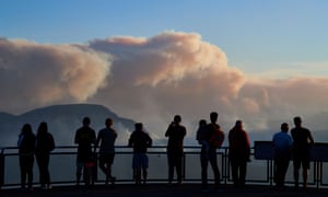 People on a viewing platform watch smoke rise from bushfires in the Blue Mountains near Katoomba, New South Wales, last month.