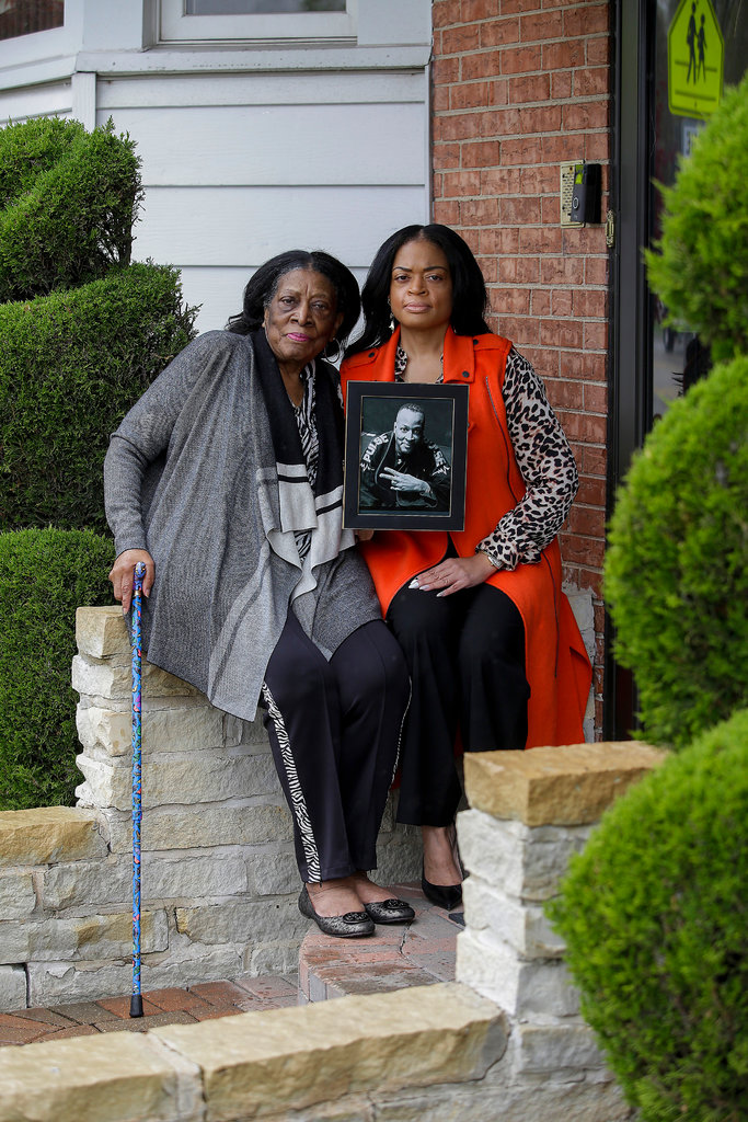 Ami Relf, right, holds a photo of her brother Reginald Relf alongside her mother, Cleona Relf, outside her mother’s home in Bellwood, Ill. Mr. Relf died there while quarantining in the basement after experiencing symptoms of Covid-19. 