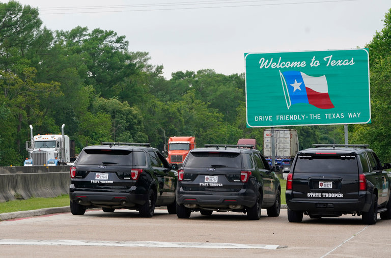 Texas state troopers parked along I-10 on April 6 at the Louisiana border. People arriving from Louisiana have been ordered to quarantine themselves. 