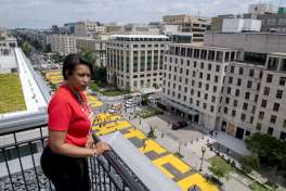 In this image provided by the Executive Office of the Mayor, District of Columbia Mayor Muriel Bowser stands on the rooftop of the Hay Adams Hotel near the White House and looks out at the words 'Black Lives Matter' that have been painted in bright yellow letters on the street by city workers and activists, Friday, June 5, 2020, in Washington. (Executive Office of the Mayor/Khalid Naji-Allah via AP)