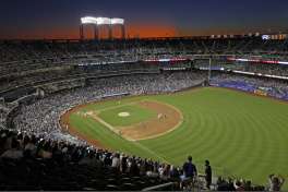 FILE - In this Aug. 29, 2019, file photo, the sun sets behind Citi Field during a baseball game between the New York Mets and the Chicago Cubs in New York. Major League Baseball players ignored claims by clubs that they need to take additional pay cuts, instead proposing they receive a far higher percentage of salaries and a commit to a longer schedule as part of a counteroffer to start the coronavirus-delayed season.