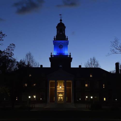 Campus building at dusk illuminated by blue lights