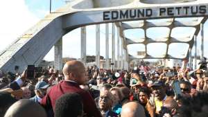 a group of people standing in front of a crowd: Support swells for renaming Edmund Pettus Bridge in Selma to honor John Lewis after his death