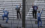 Kevin Harvick, second from left, and some members of the team's crew climbed the fence after Harvick won the Brickyard 400 at Indianapolis Motor Speed