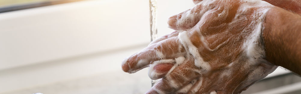 close-up of a man washing his hands with soap and water