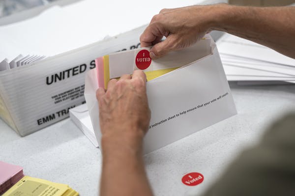 Todd Gallagher prepares mail in ballot envelopes including an I Voted sticker, July 29, in Minneapolis.