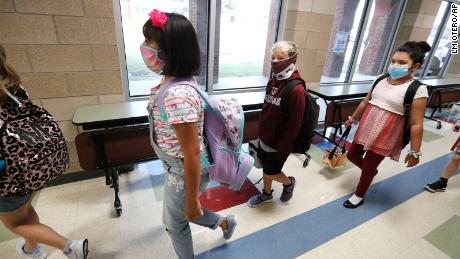 Wearing masks to prevent the spread of COVID19, elementary school students walk to class to begin their school day in Godley, Texas, Wednesday, Aug. 5, 2020. Three rural school districts in Johnson County were among the first in Texas to head back to school for in person classes for students. (AP Photo/LM Otero)