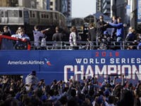 Chicago Cubs president of baseball operations Theo Epstein and general manager Jed Hoyer, right, point to each other as they acknowledge fans during a