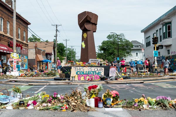 At the site where George Floyd was killed while in police custody in Minneapolis, a memorial on Monday was filled with flowers, signs and messages.