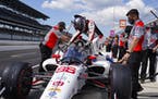 Marco Andretti climbs into his car during practice for the Indianapolis 500 auto race at Indianapolis Motor Speedway in Indianapolis, Friday, Aug. 14,