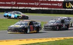 Tyler Reddick, driver of the #8 Cat App Chevrolet, leads John Hunter Nemechek, driver of the #38 Death Wish Coffee Ford, and Daniel Suarez, driver of 