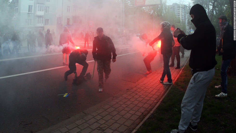 Pro-Russia militants, armed with baseball bats and iron bars, hold flares as they attack people marching for national unity in Donetsk on Monday, April 28. 