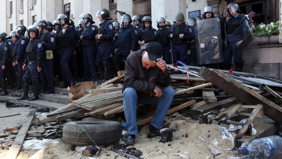 A pro-Russian activist sits in front of policemen guarding the burned trade union building in Odessa on May 3.