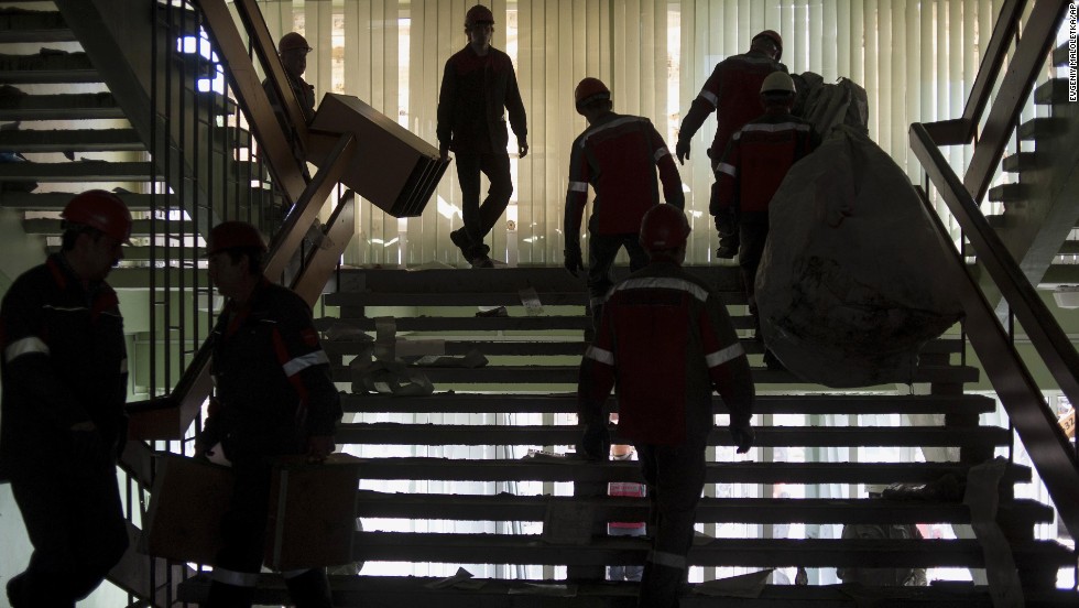 Employees of the Ukrainian company Metinvest clear away debris in a government building in Mariupol, Ukraine, on Friday, May 16, after pro-Russian separatists relinquished their hold on it. 