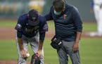Twins starting pitcher Jake Odorizzi, left, is checked on by a trainer after getting hit by a ball during the fourth inning