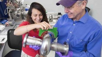 SQMS Director Anna Grassellino and Deputy Director James Sauls hold a superconducting radio-frequency cavity inside the Material Science Lab at the Department of Energy’s Fermi National Accelerator Laboratory. Credit: Reidar Hahn, Fermilab