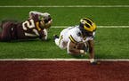 Michigan wide receiver Daniel Jackson lunged into the end zone for a fourth-quarter touchdown in the Wolverines' 49-24 victory over the Gophers on Sat
