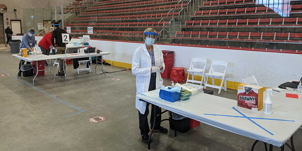 Clinician standing at a vaccination station at the MIT flu clinic
