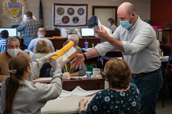 Luzerne County Bureau of Elections officials and city employees sorted through and counted mail-in and absentee ballots in Wilkes-Barre, Pa.