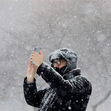 Image: A person uses a mobile phone at the Washington Square Park during a snow storm in New York