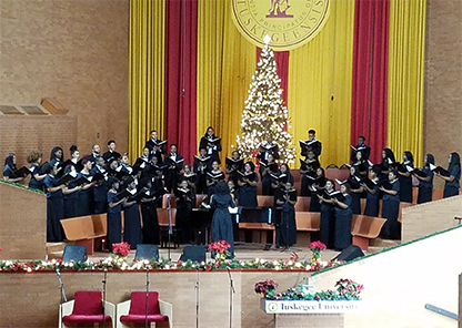 Golden Voices Concert Choir in choirstand with a Christmas tree in the background
