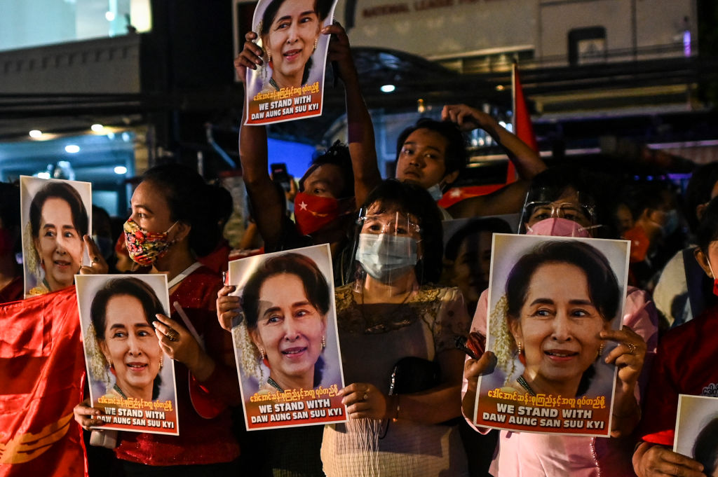 Supporters of the National League for Democracy (NLD) party hold posters with the image of Myanmar state counsellor Aung San Suu Kyi as supporters celebrate in front of the party's headquarters in Yangon on November 9, 2020, as NLD officials said they were confident of a landslide victory in the weekend's election.