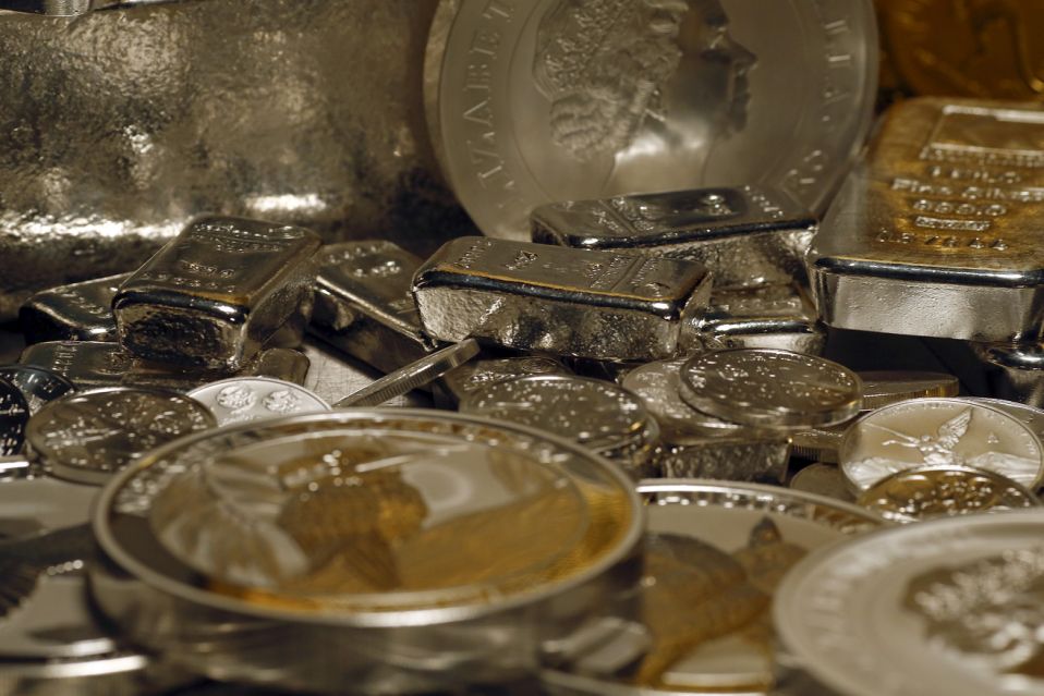 Silver bars and coins are stacked  on a table in the safe deposit boxes room of the ProAurum gold house in Munich March 3, 2014. Gold gained around 1.5 percent on Monday as escalating tensions between Ukraine and Russia bolstered demand for assets perceived to be relatively safe, hitting riskier investments such as equities. Silver followed gold's moves and rose 1.3 percent to $21.46 an ounce. Platinum was up 0.7 percent at $1,450.00 an ounce and palladium gained 0.6 percent at $743.80 an ounce.    REUTERS/Michael Dalder(GERMANY - Tags: BUSINESS COMMODITIES SOCIETY)