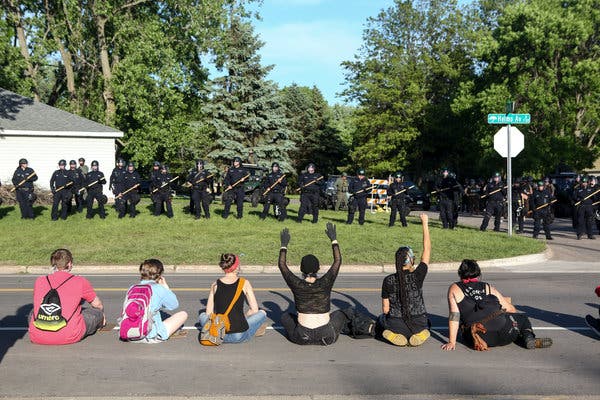 Protesters lined up opposite members of the police near the home of Derek Chauvin, a former Minneapolis police officer, in Oakdale, Minn., on Thursday.