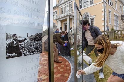 Left to right: Joao Galafassi, Jack Grossman and Harper Wilson of the Martin Luther King in Connecticut Committee clean the five glass panels honoring King and his time in Connecticut, placed outside the Simsbury Free Library. In 1944, when King was a teenager, he spent a summer picking tobacco in Simsbury.