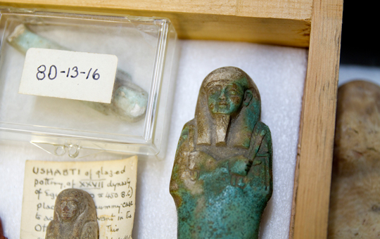 Small Egyptian artifacts in a storage box
