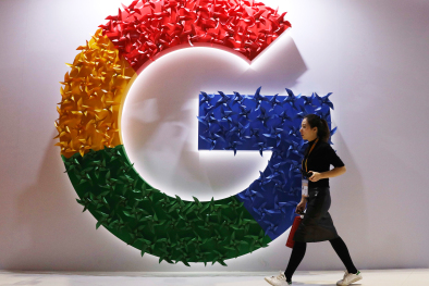 FILE - In this Monday, Nov. 5, 2018 file photo, a woman walks past the logo for Google at the China International Import Expo in Shanghai. Google says it's making progress on plans to revamp Chrome user tracking technology aimed at improving privacy even as it faces challenges from regulators and officials.  The company gave an update Monday, Jan. 25, 2021 on its work to remove from its Chrome browser so-called third-party cookies, which are used by a website's advertisers or partners and can be used to track user browsing habits across the internet.  (AP Photo/Ng Han Guan, File)