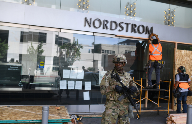 Nordstrom in Santa Monica under the watch of National Guard as its boarded up Monday.