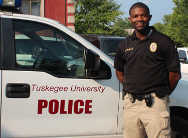 TU police officer standing next to car