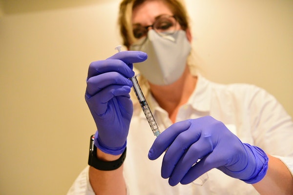 This Sept. 2020 photo provided by Johnson & Johnson shows a clinician preparing to administer investigational Janssen COVID-19 vaccine. 