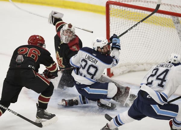 Blaine's Braeden Lindsay (29) attempts to get the puck in Maple Grove goal .