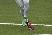 Saints running back Alvin Kamara wore Christmas-colored cleats during warm-ups Friday.