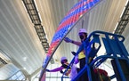 Jen Lewin (right) helped install lights on “The Aurora,” her new public artwork at MSP Airport.