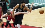 Chicago Bulls forward Luke Kornet, left, and Timberwolves center Karl-Anthony Towns battle for a loose ball during the first half 