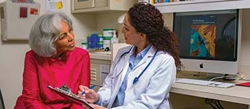 Older adult discussing Alzheimer's treatment with her doctor