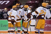 Gophers  defenseman Jackson LaCombe (2) celebrated with teammates after scoring a goal during the first period Friday.