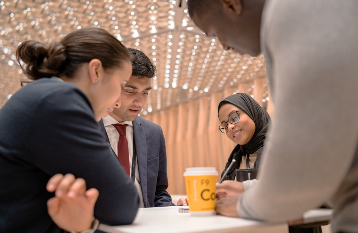 A diverse group of employees discuss a project at the Bloomberg offices.