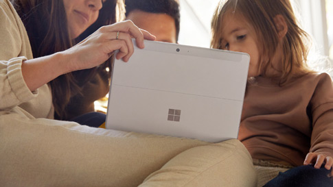 Family members gathered around a Surface computer