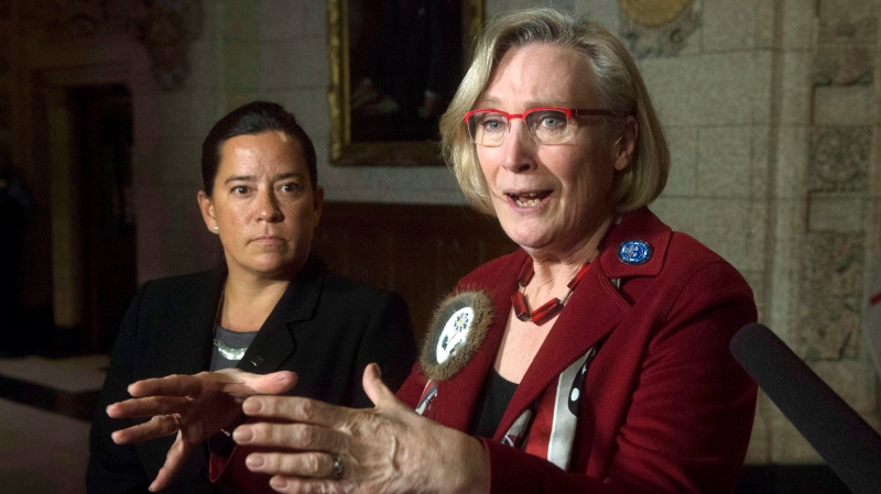Then-Minister of Justice and Attorney General of Canada Jody Wilson-Raybould, left, looks on as Minister of Indigenous and Northern Affairs Carolyn Bennett speaks about the Canadian Human Rights Tribunal regarding discrimination against First Nations children in care during a news conference on Parliament Hill in Ottawa, Tuesday, January 26, 2016. THE CANADIAN PRESS/Adrian Wyld 