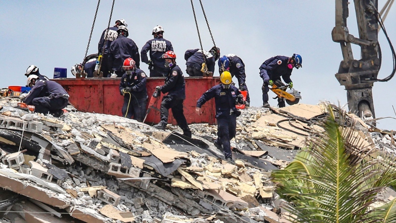 South Florida Urban Search and Rescue team look for survivors at the 12-story oceanfront condo, Champlain Towers South on Saturday, June 26, 2021, that partially collapsed early Thursday morning in the Surfside area of Miami. (Al Diaz/Miami Herald via AP) 