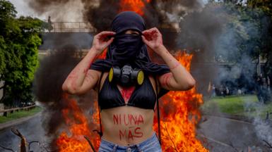 A protester stands in front of a fire during a protest in Medellín, Colombia, on 18 May 2021