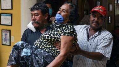 Relatives carry a woman with symptoms of Covid-19 in Chiapas state