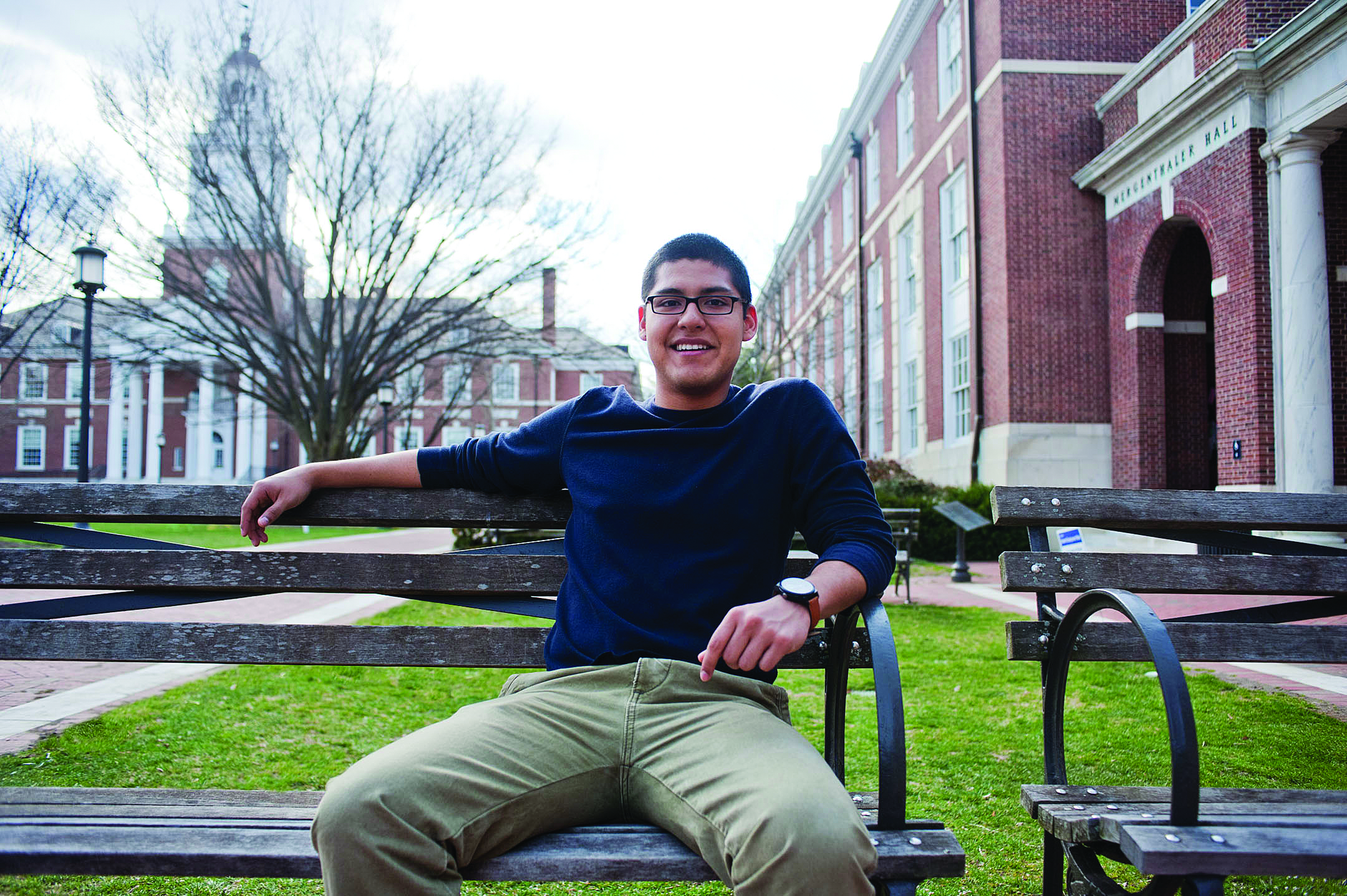 Hopkins student Diego sits on a bench on campus