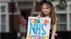 Girl holds sign saying thank you nhs and my mummy