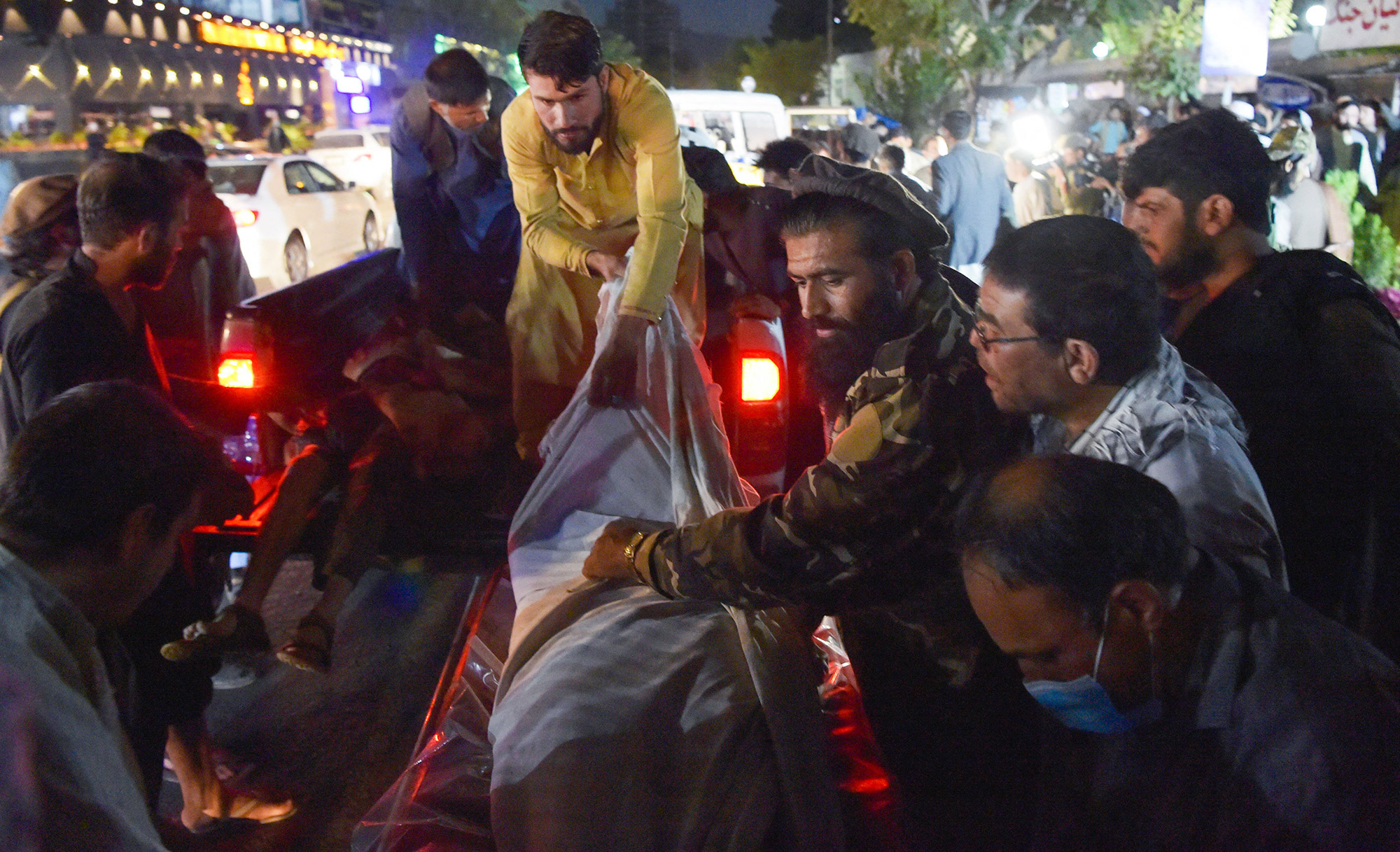 Volunteers and medical staff unload bodies outside a hospital after the bomb blasts at the Kabul airport on August 26. 